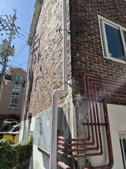 더 큰 구경으로 교체되고 주변이 정리된 우수관 배관