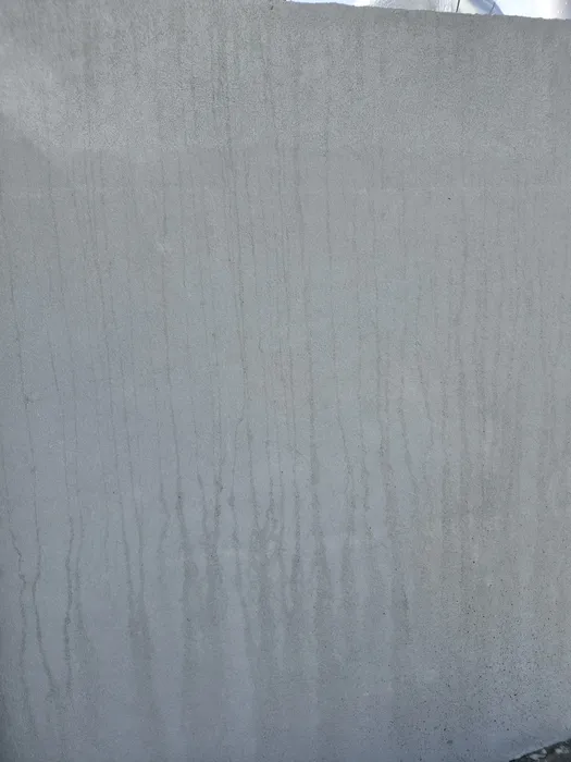 옥상 파라펫 외벽에 세로로 물 자국이 번진 회색 벽면
